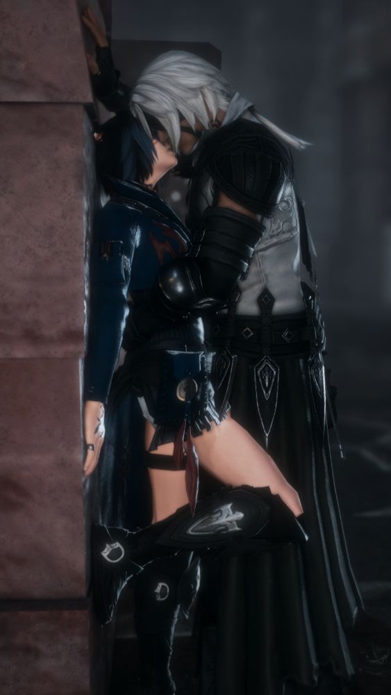 A screenshot from FFXIV of Karo (a Miqo'te with short black and blue hair) being pinned to a wall, in the rain, by Thancred.  Karo is in a dark blue top, shorts and knee night black boots, and Thancred is in his heavensward outfit.
