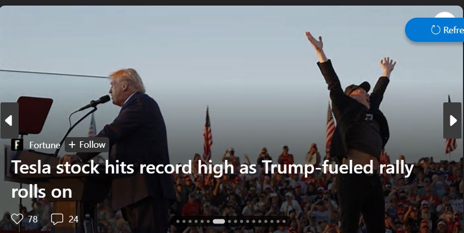 A picture of Donald Trump speaking at a rally with Elon Musk behind him with his hands in the air. The quote on the picture states: Tesla stock hits record high as Trump-fueled rally rolls on.