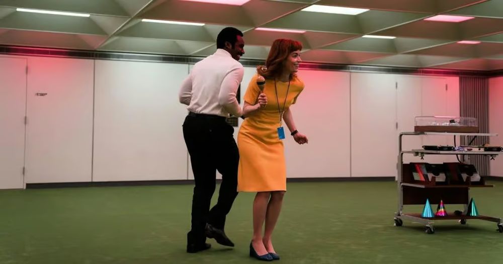 TV still from Severance S1 featuring Milchick (Tramell Tillman) and Helly R (Britt Lower) dancing at the "Music Dance Experience"