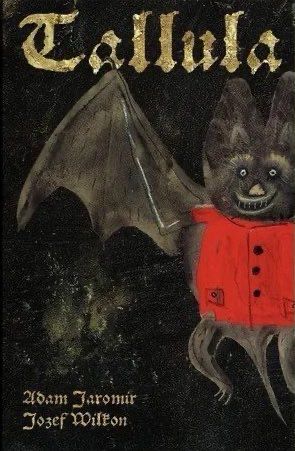 Cover of the book Tallula, Königin der Nacht (Tallula, Queen of the Night) by Adam Jaromir and Jozef Wilkon. 
The cover art features a stylized bat character with large ears, a wide smile, and a red jacket with black buttons. The bat's wings are spread out, and the background is dark and textured. The title "Tallula" is written in a golden, ornate font at the top of the cover, with the authors' names listed at the bottom.