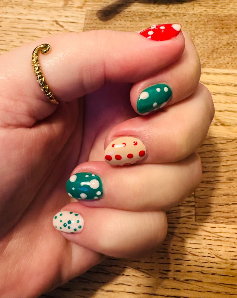 Photo of my nails in green and red, beige and white with polka dots in various shades and sizes.