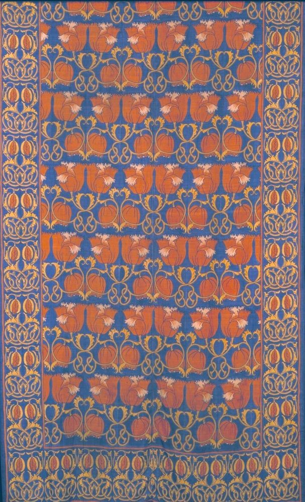 A bed cover designed by C. F. A. Voysey.
The textile features a repeating pattern on a blue background. The main body of the design consists of horizontal bands with stylized orange, pumpkin-like shapes and floral motifs. These bands are separated by decorative rows of intertwined yellow and orange organic shapes. The bed cover is framed by a wide border on the sides and at the bottom, which is filled with an intricate pattern of similar stylized floral and swirling vine motifs.