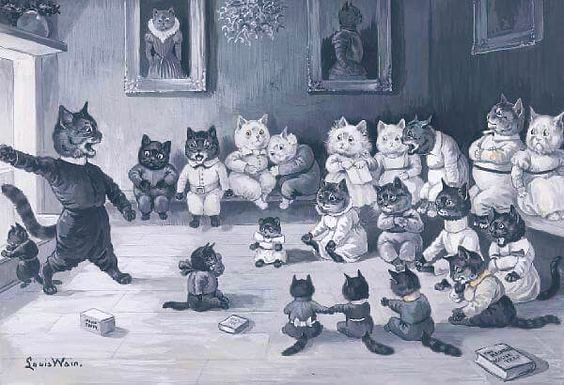 A painting by Louis Wain, titled The Ghost Story. It depicts an anthropomorphized scene where numerous cats are gathered indoors for a storytelling session. 
On the left, a large black cat dressed in dark clothing stands animatedly, gesturing with one paw extended and its mouth open as if mid-speech. A group of approximately twenty other cats, varying in size, sit on the floor and on a bench, listening. Some cats are young kittens sitting on the floor in the foreground. Others are older, seated on a bench or chairs, some wearing clothing like jackets or dresses. The room features framed portraits on the wall, a small table with a vase of flowers, and a window letting in light from the left. Small objects resembling books or boxes are on the floor. The artist's signature, "Louis Wain," is visible in the bottom left corner.