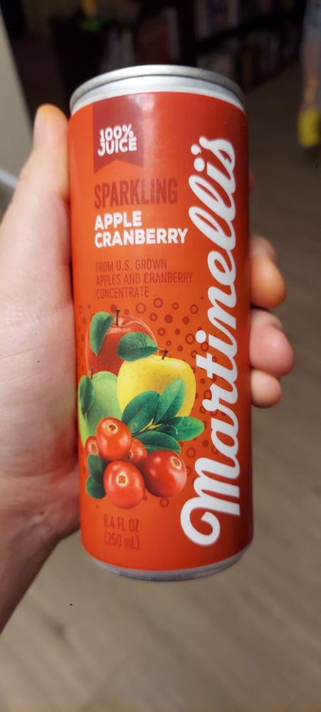 a small red can with apples and cranberries on it