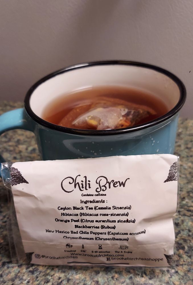 a mug of tea with a tea packet propped in front of it