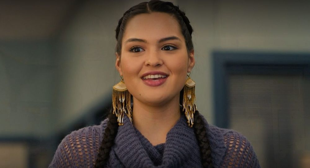 Siaja wearing brown and white earrings with multiple dangling threads attached to a solid triangle top