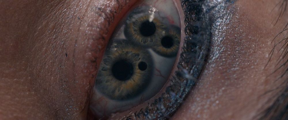 a still from the film The Substance shows an splitting with multiple pupils and irises