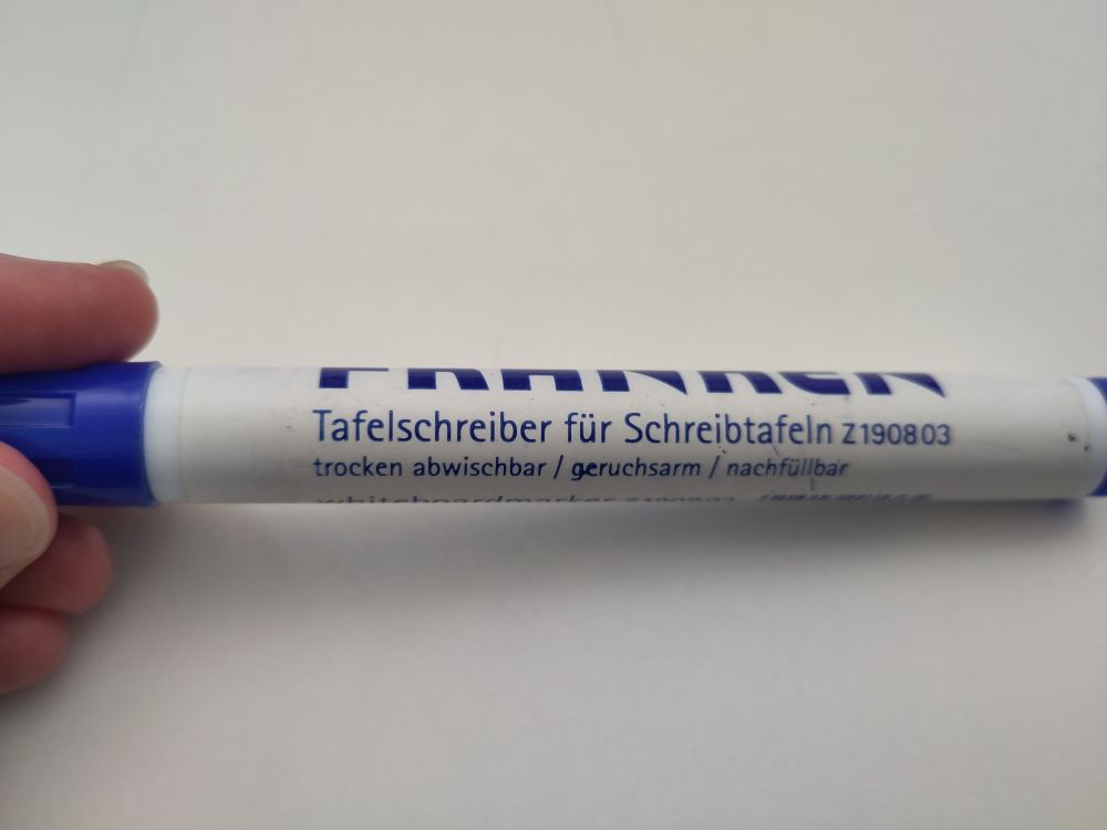 Foto eines Filzstifts von der Seite. Darauf steht der Aufdruck "Tafelschreiber für Schreibtafeln".