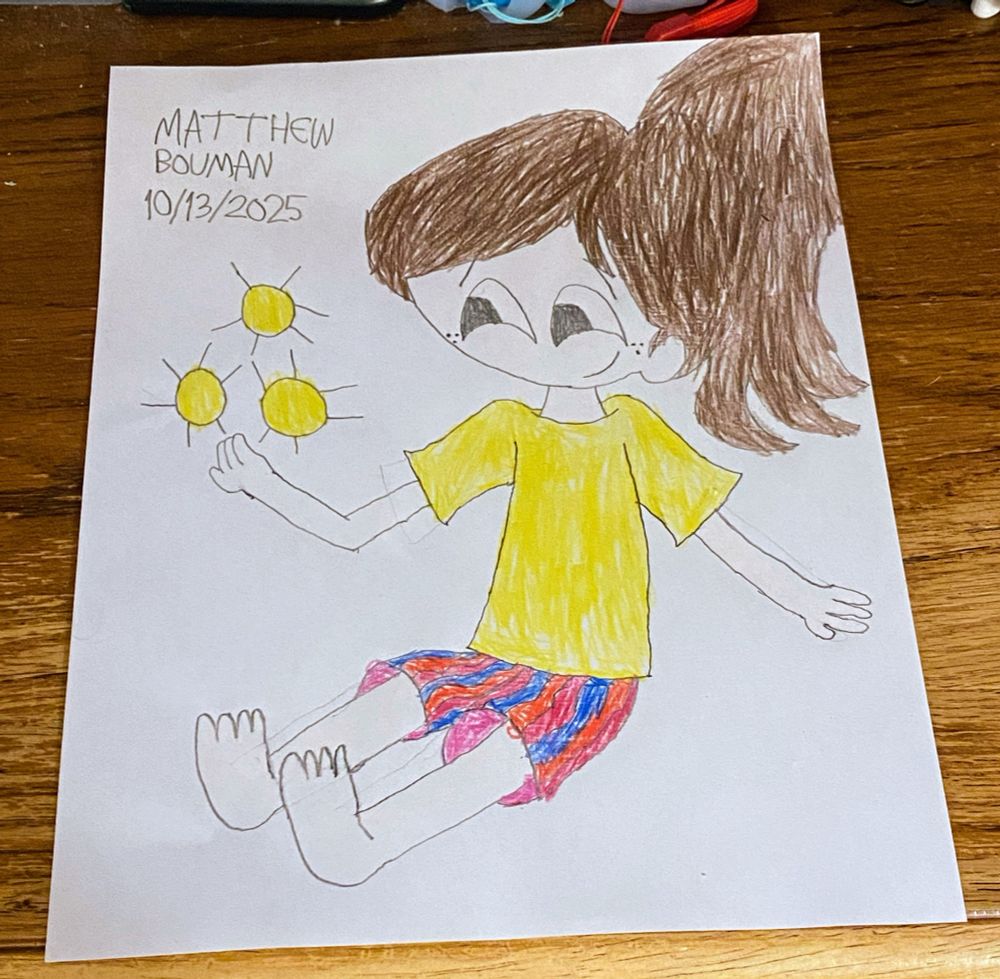 Jenny sitting, smiling and making 3 glowing balls of light float in front of her.