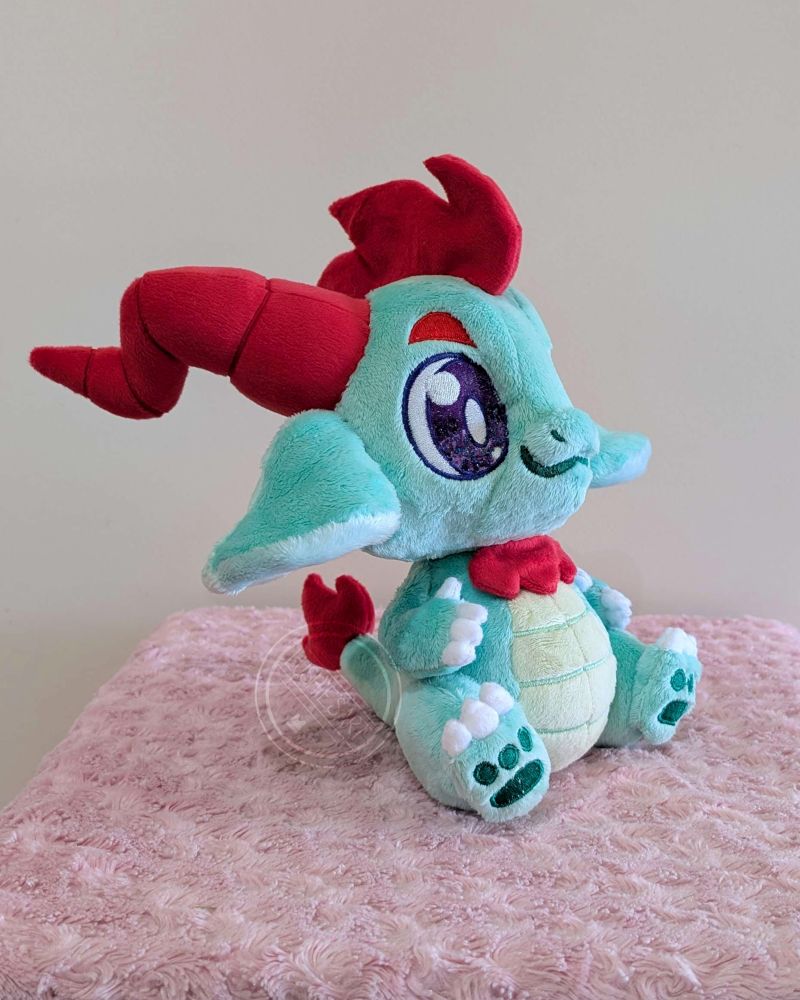 Side view of the green dragon plushie.