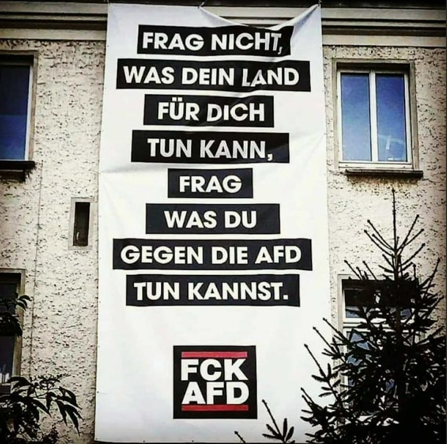 Großes Banner an einem Haus. Aufschrift:
FRAG NICHT, WAS DEIN LAND FÜR DICH TUN KANN,
FRAG WAS DU GEGEN DIE AFD TUN KANNST.
FCK
AFD