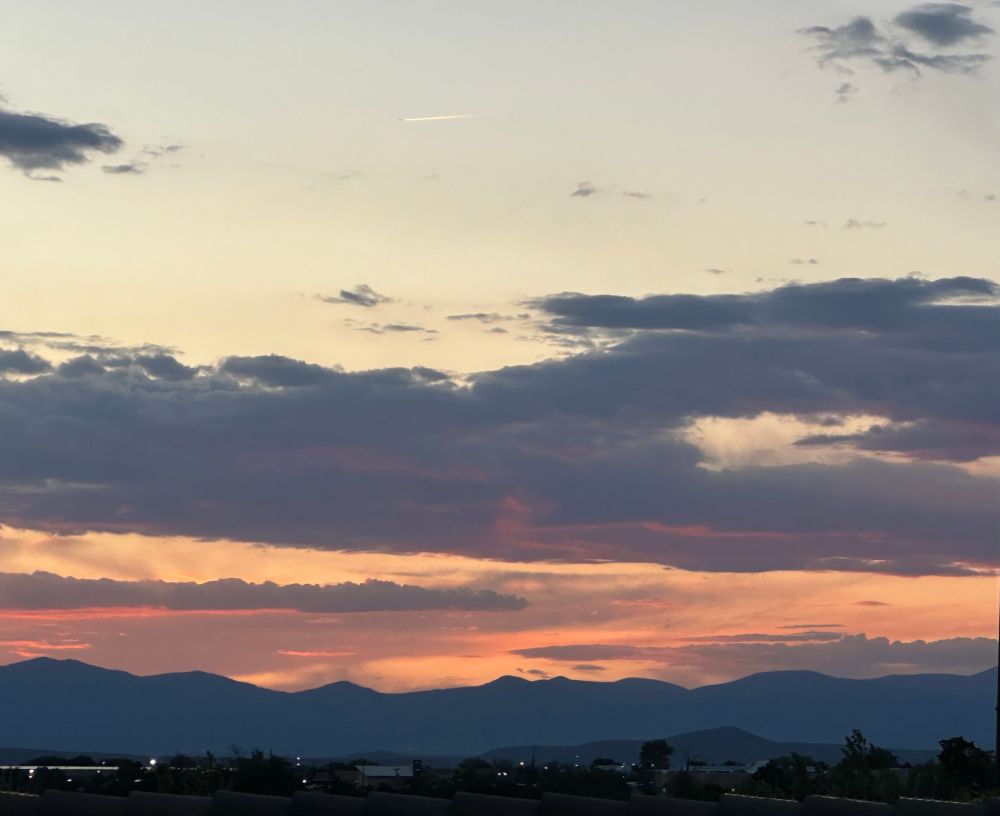 City lights coming on, some nice pink and orange clouds at sunset.  Mountain silhouette
And a plane streaking across the sky 