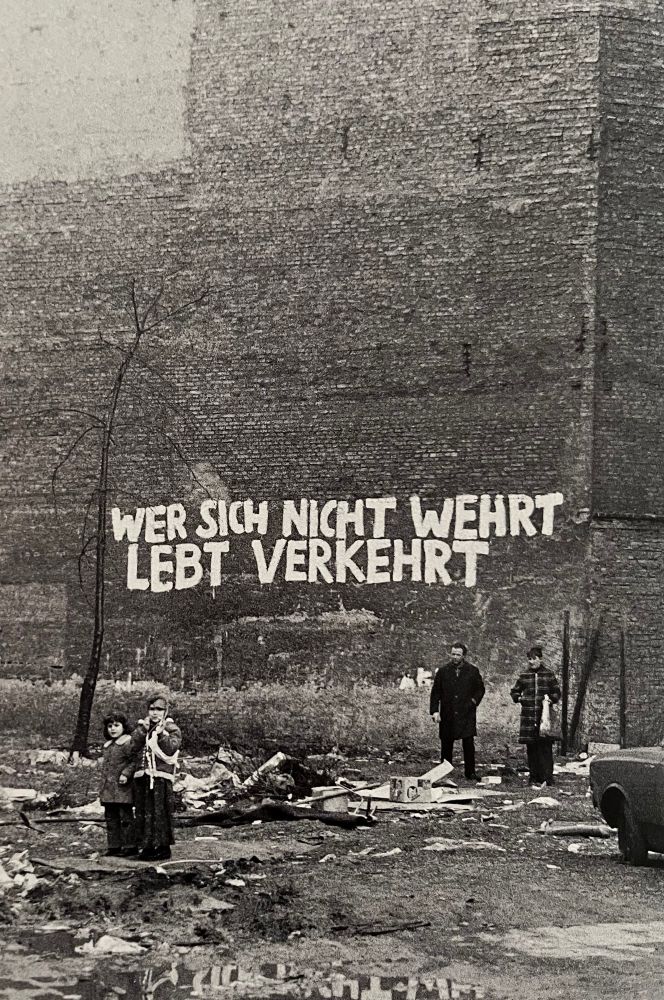 1978 Foto aus der Adalbertstr. mit Kindern vor einer Brandmauer mit Schriftzug: Wer sich nicht wehrt lebt verkehrt