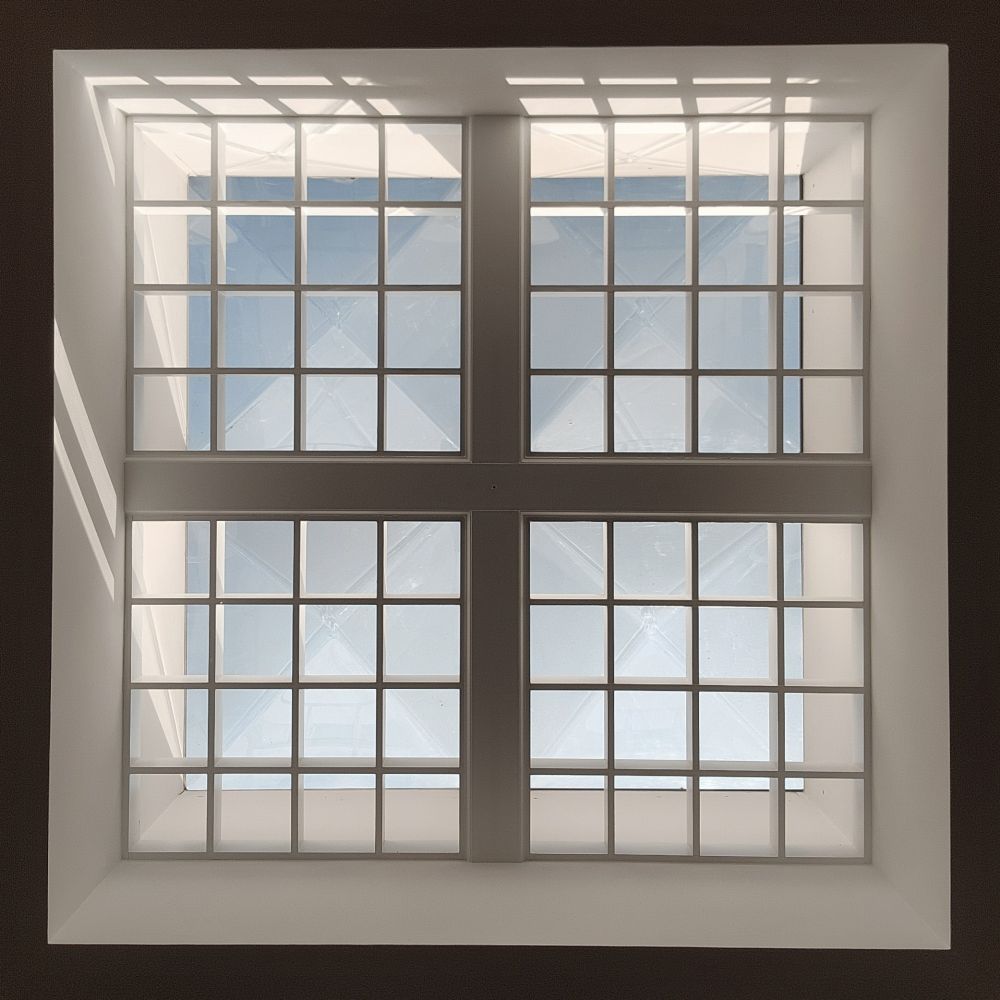 Squares in squares! This is a skylight in a building in Pennsylvania, shot by putting my phone flat on the floor and pointing upward. It's a large square made of 4 medium squares, each divided into 16 squares, with light and shadows playing all around 