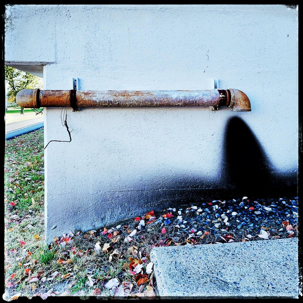 photo. exhauste pipe for a generator in a parking garage. with black soot on wall,