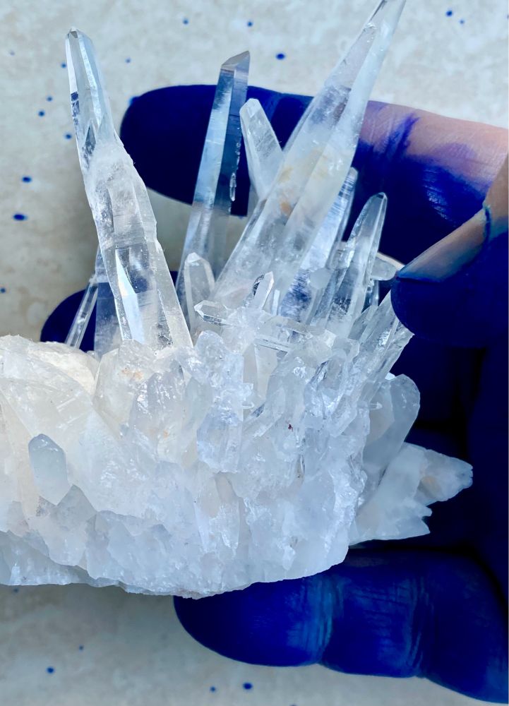 Fountain pen ink covered hand holding a quartz crystal from Peru.