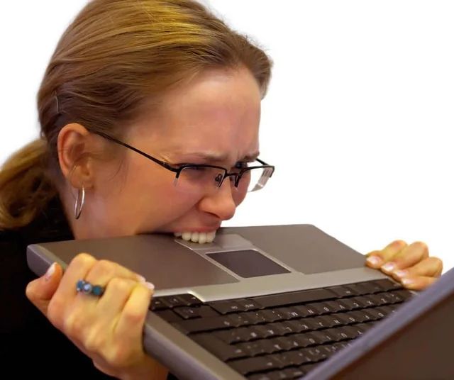 Woman biting computer in rage