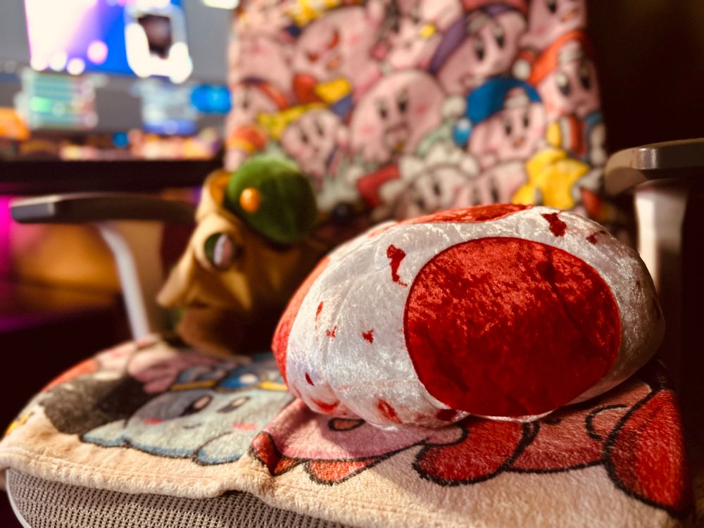 A toad cap with fake blood on it on Slonko’s chair with a tonberry behind it. 