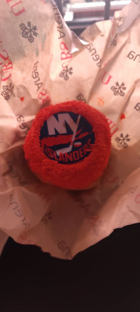 Alt text a photo of a donut with a ring of orange sprinkles and the #isles logo in the center 