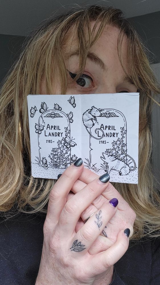 April Landry is holding open the scene and it is the same gravestone being visited by possums and butterflies