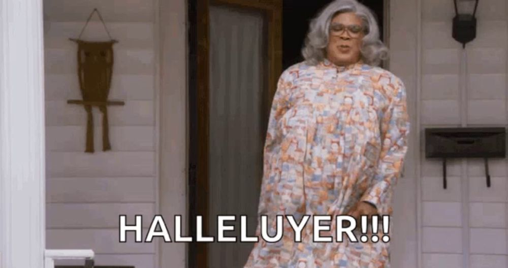 a woman in a floral dress is standing in front of a door and says halleluyer .