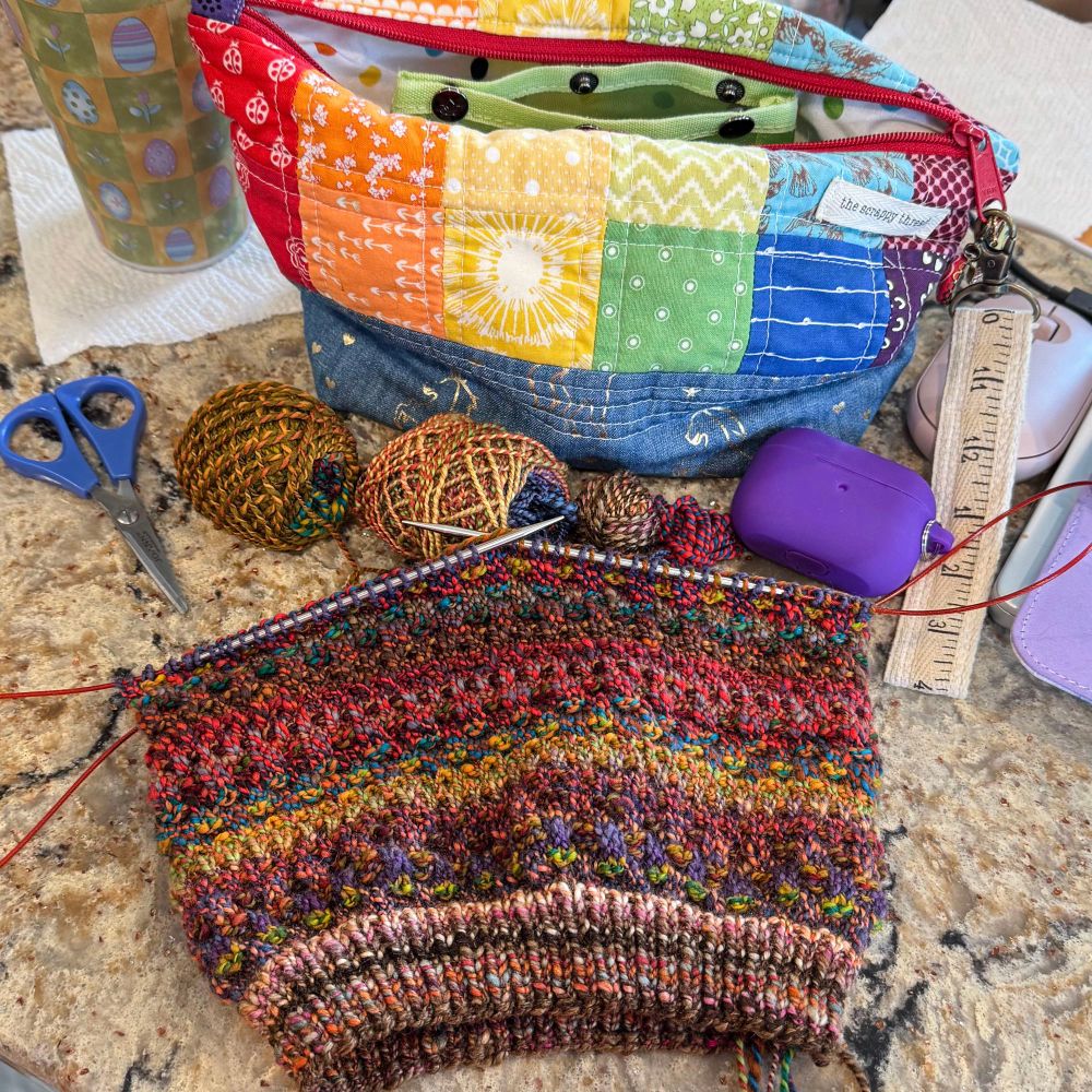 A work in progress handknit hat using various colors of handspun yarn scraps 
