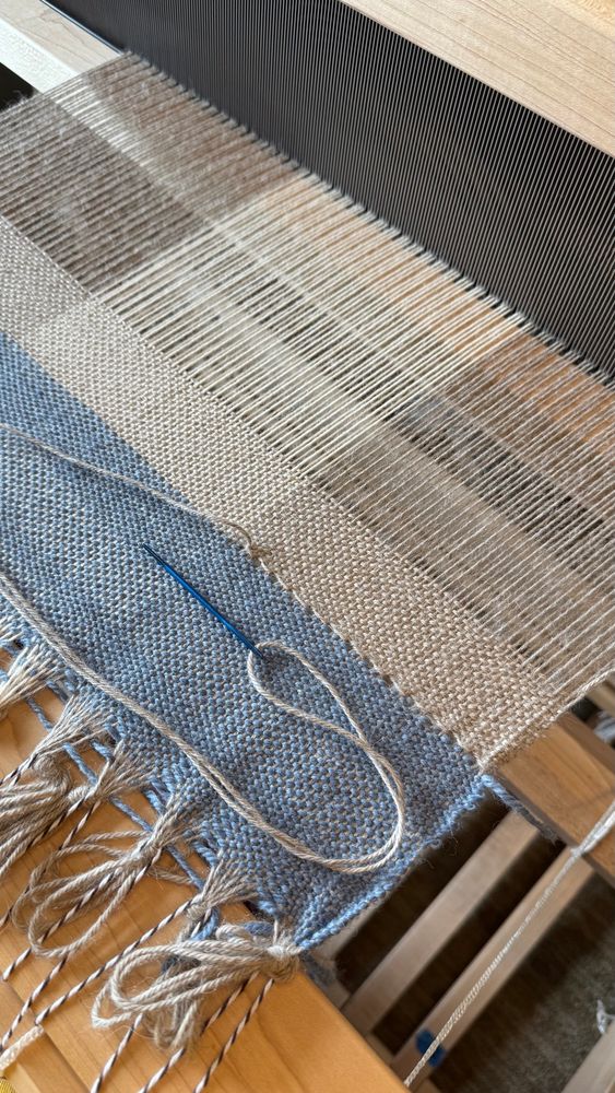 Weaving on the loom- tan and cream alpaca blend yarn with blue waste yarn. Hem stitching in progress.