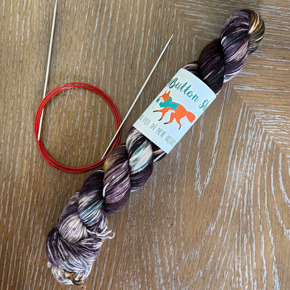 Yarn skein from Teeny Button Studio - colors are dark grays, browns, with a hint of white and green