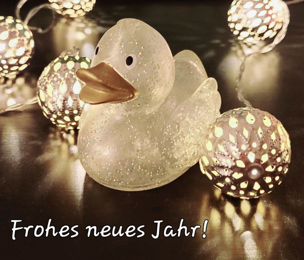 Glitzer-Badeente umringt von Leuchtkugeln. Darunter ein Text: Frohes neues Jahr!