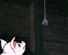 A screenshot from the 1973 animated film "Charlotte's Web". Wilbur (voiced by Henry Gibson), a pig, looks up at Charlotte (voiced by Debbie Reynolds), a barn spider who is danging from the ceiling with a strand of her own web. 