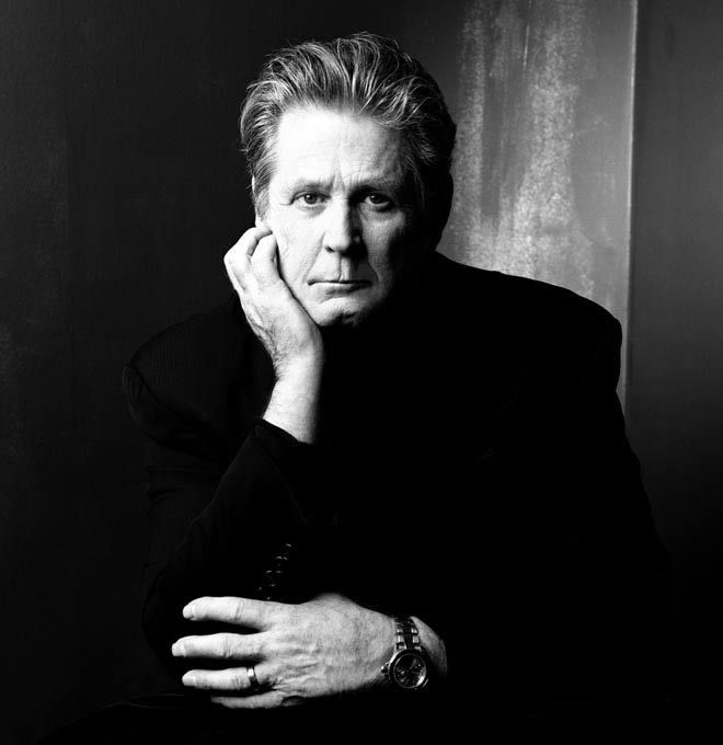 Brian Wilson en una fotografía promocional reciente, en blanco y negro, serio pero calmado y mirándonos fijamente con una mano en la barbilla.