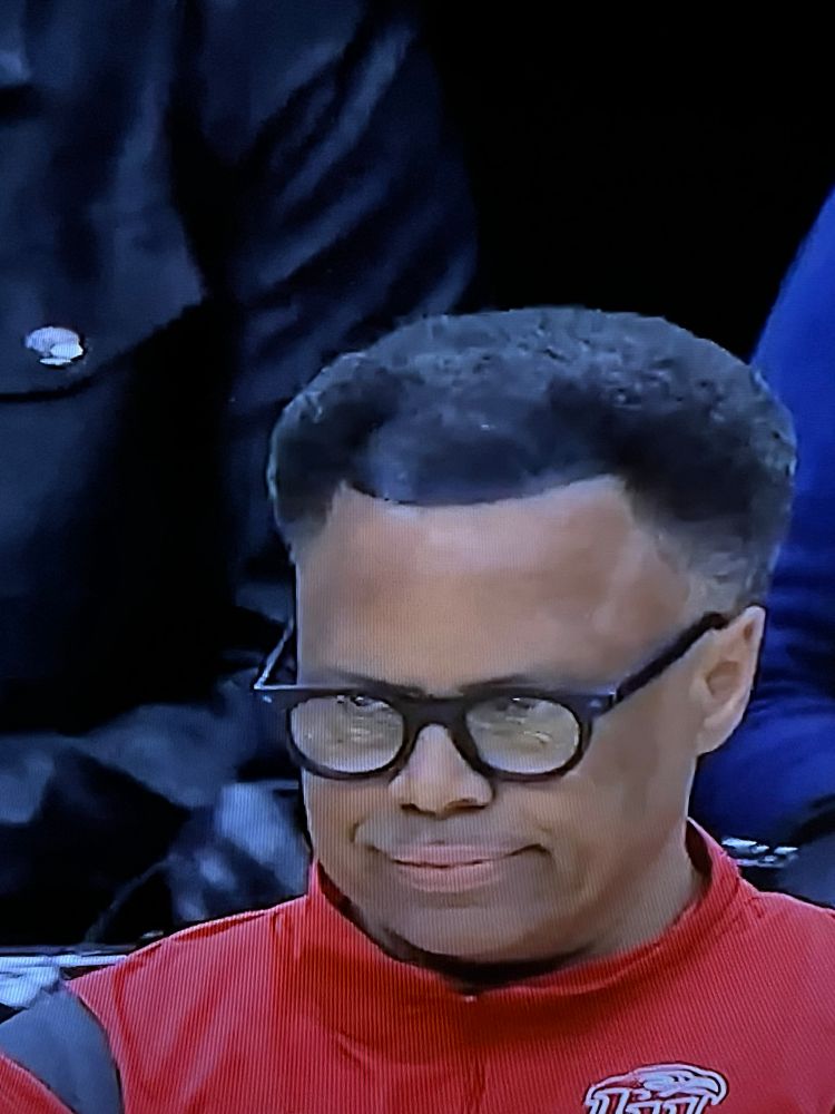 Liberty basketball coach seems to have spray painted a semi-circle of “hair” to cover up a receding hair line. 
