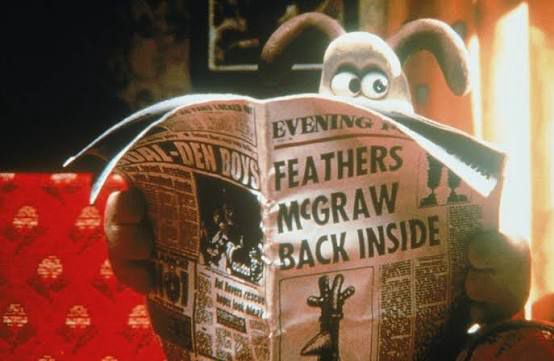 Gromit the claymation dog is looking up from reading a newspaper, eyebrows raised. The headline is “FEATHERS McGRAW BACK INSIDE,” with a photo of a penguin wearing a kitchen glove on its head to look like a rooster.