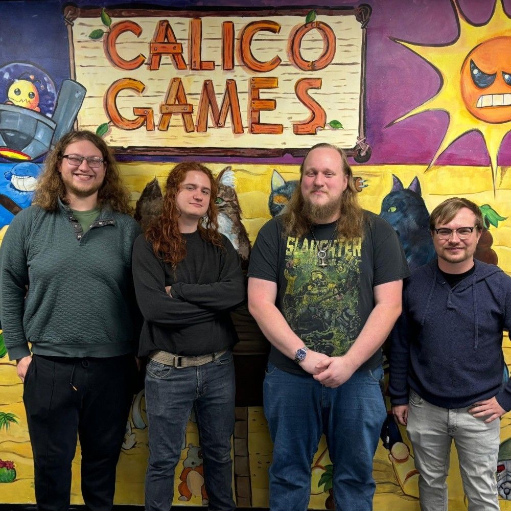 Four young salespeople stand in front of a colorful mural which reads CALICO GAMES.