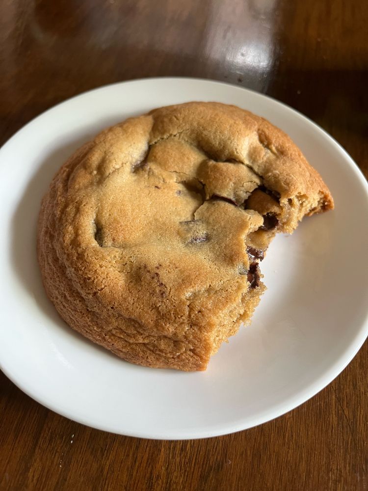 Giant chocolate chip cookie missing a couple of bites. 