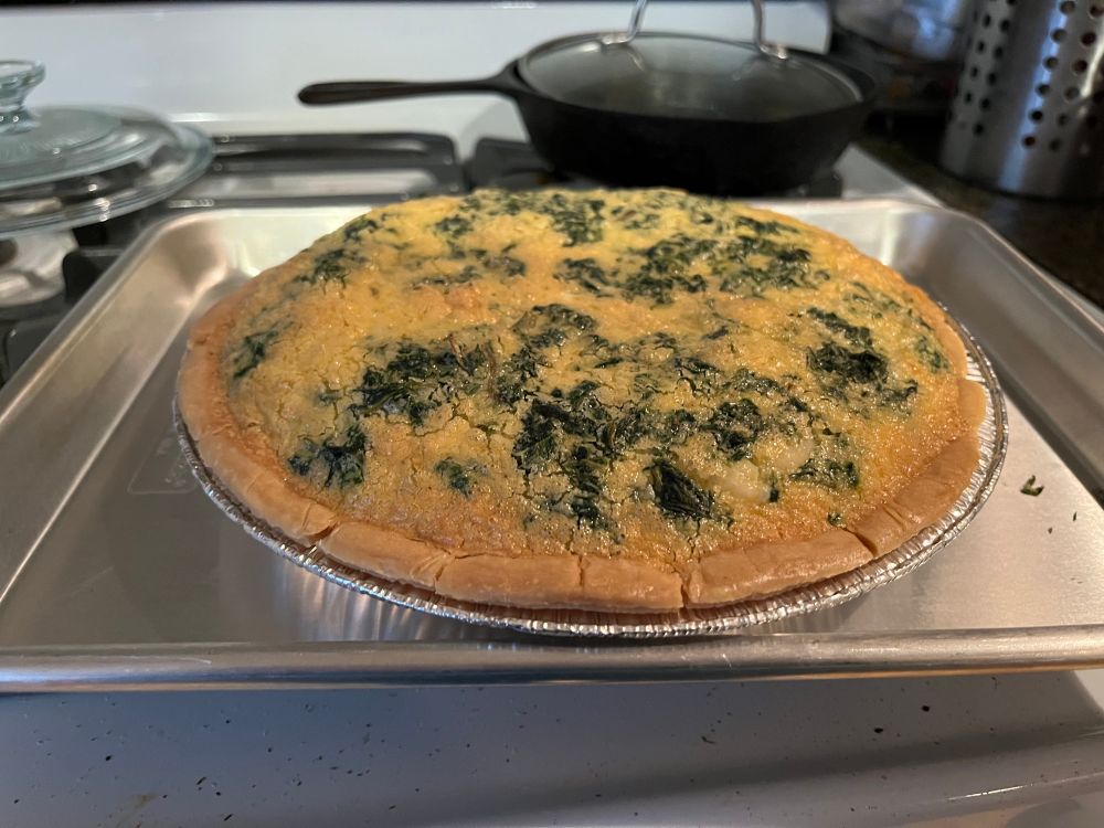Baked spinach quiche on a small baking tray. 