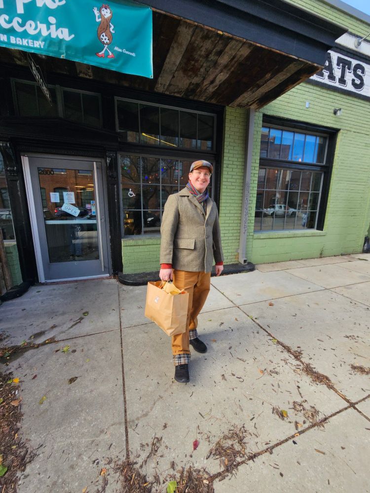 Myself in front of Doppio (a local queer coffee shop in Charles Village) carrying a bag from The Charmer's Club (a local queer thrift shop across the street). We got a delightful crocheted blanket in autumnal colors and and some beautiful mugs for 30 bucks!