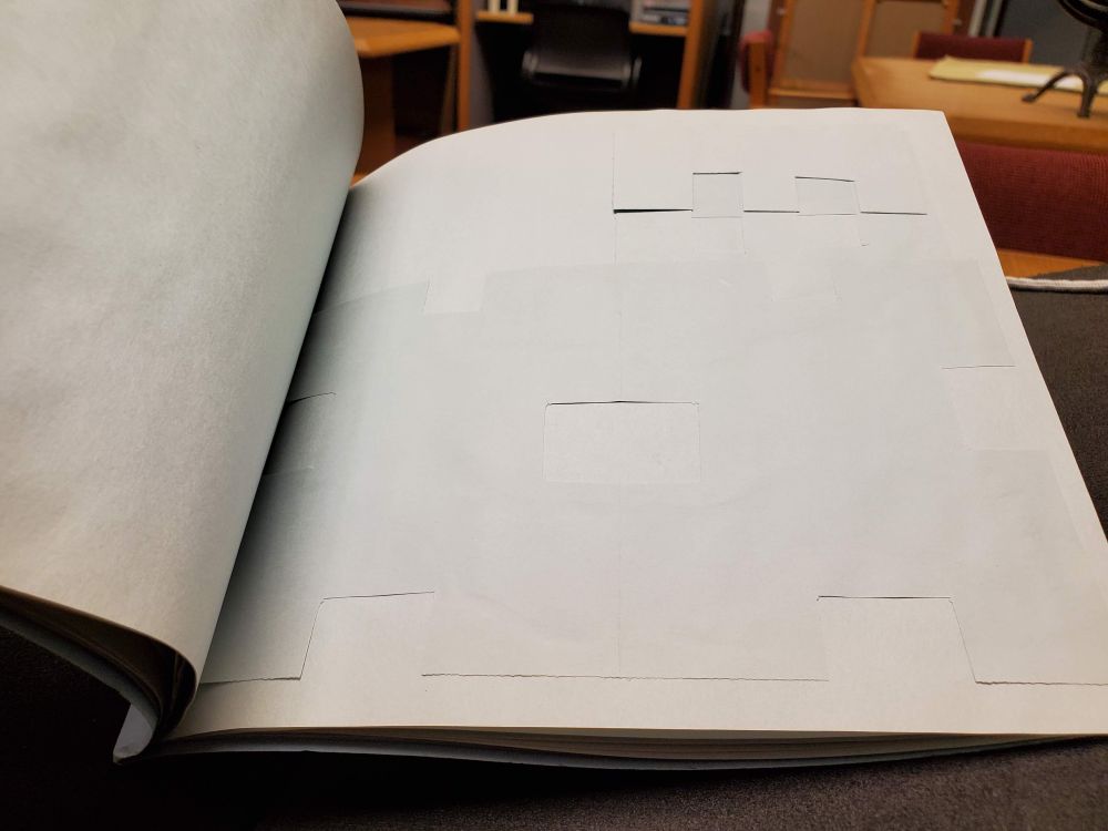 A photo of a book open to a page of folded paper, glued on.