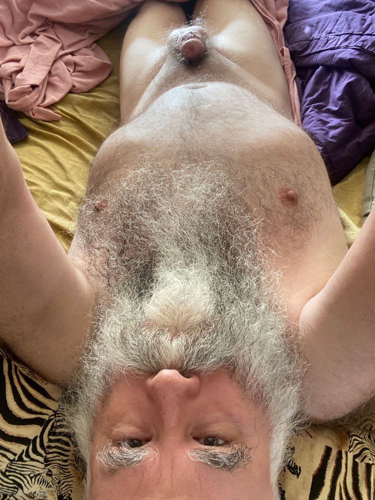 lying in bed naked you can see from my forehead to the thighs I'm on mustard colored sheets with pink and purple sheets off to the side.