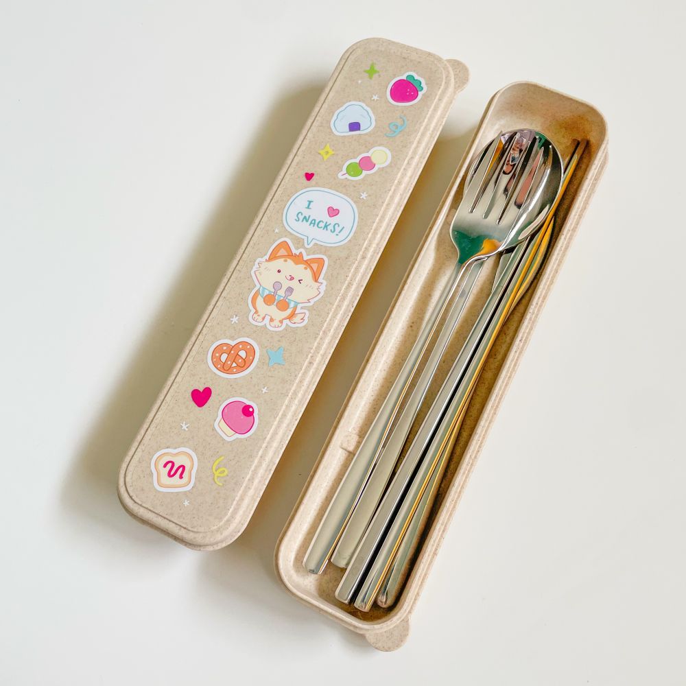 A cute beige utensil set with a cartoon dog design on the box top. It says “I love snacks!”