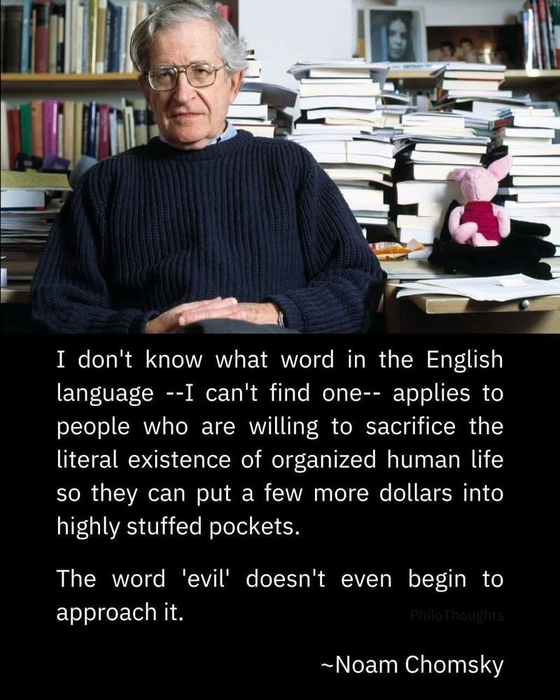 An older man with glasses in a navy sweater sits in front of a desk piled with books. Below in white text on a black background is the following quote "I don't know what word in the English language --I can't find one-- applies to people who are willing to sacrifice the literal existence of organized human life so they can put a few more dollars into highly stuffed pockets. The word 'evil' doesn't even begin to approach it." Noam Chomsky