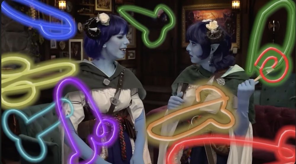 Laura Bailey and Ginny Di in costume as Jester from Critical Role, surrounded by colorful drawings of things that definitely aren't dicks, because that would violate Twitch's terms of service. (Cough.)