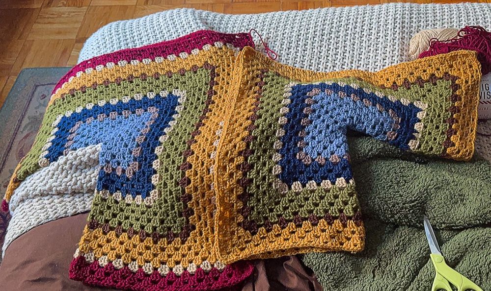 two crocheted hexagons folded into L shapes; made of blue, green, yellow, and red yarns 