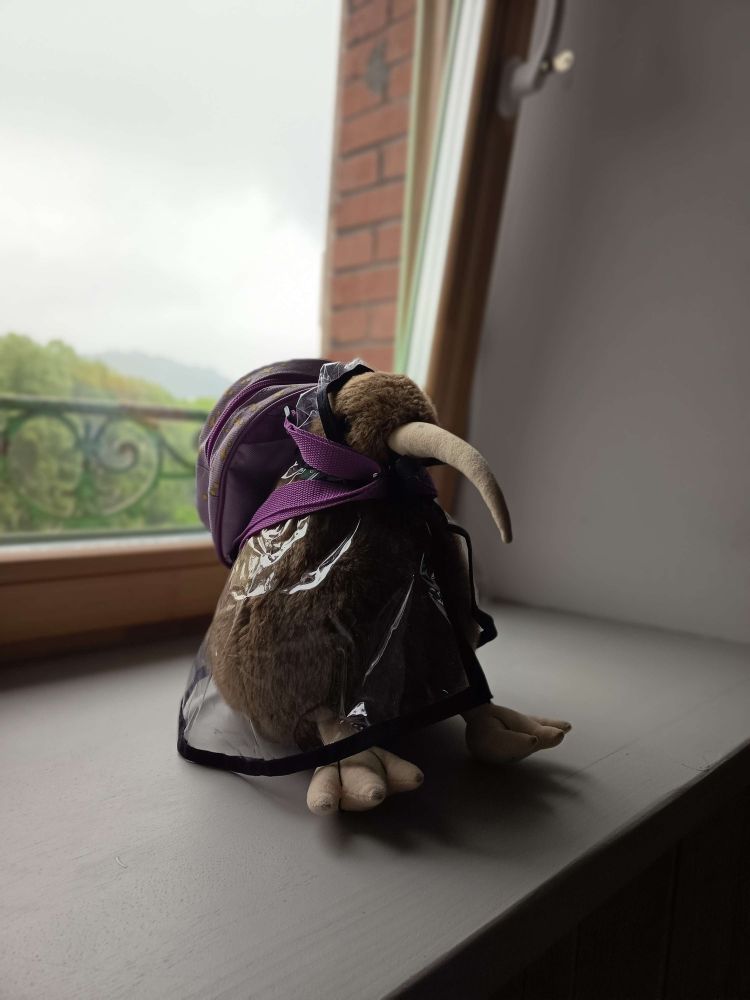 Photo de Azi posant dans un kway avec petit sac à dos violet sur les épaules