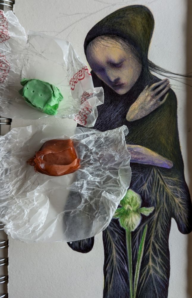 mixed media drawing in progress with two pieces of taffy candy sitting on top of the drawing 