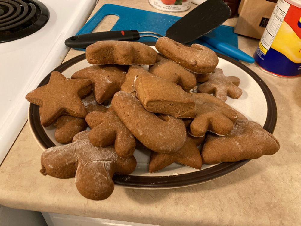 A platter of chonky gingerbread cookies, with some light flour dusting from when the dough was rolled out. They are thicc and they are delicious