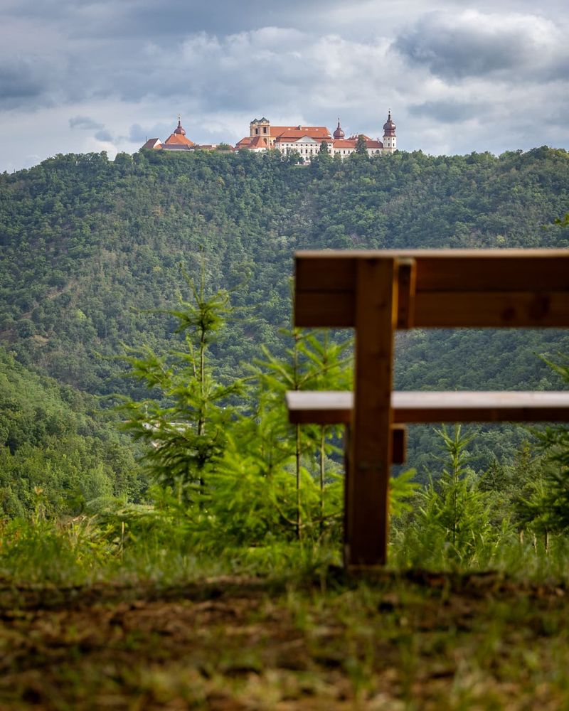 A bench in the foreground, a mountain and the the Göttweig Abbey in the background.