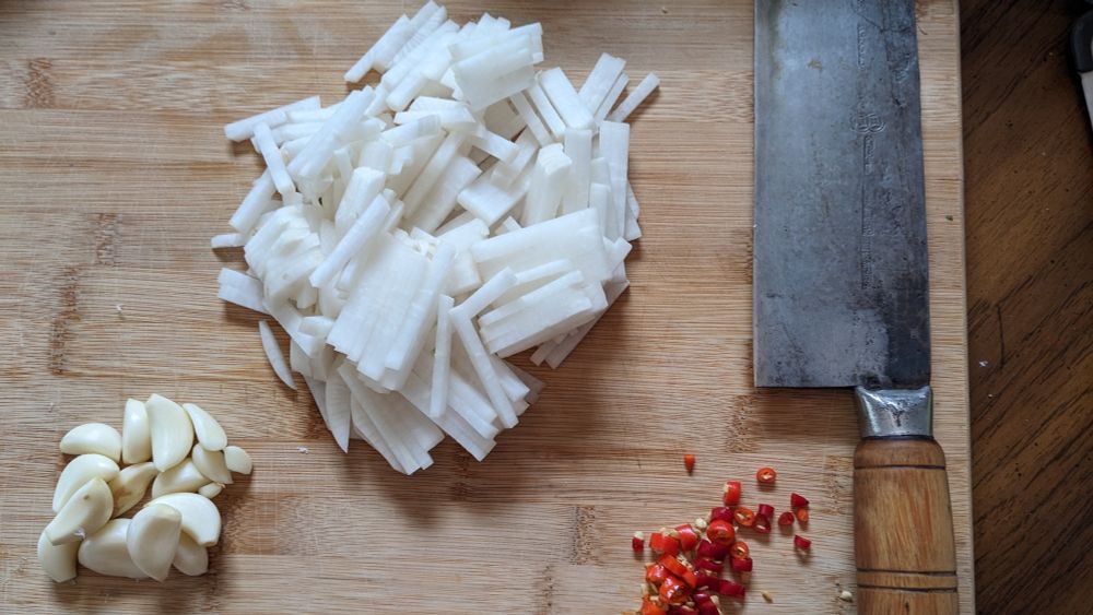 cut piles of daikon, garlic, and chili on a cutting board