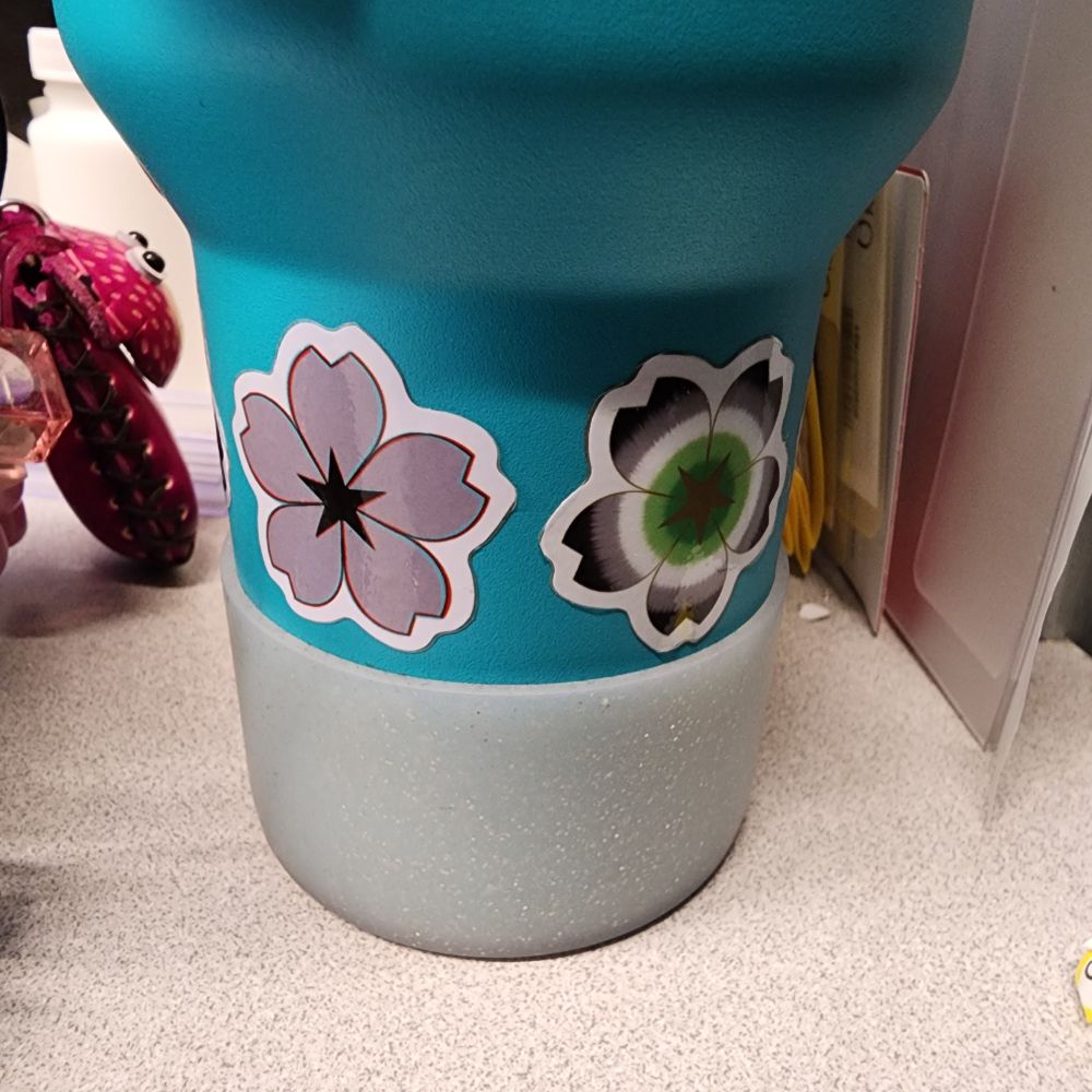 Stanley with a darkiplier flower sticker and a Aromantic flower sticker
