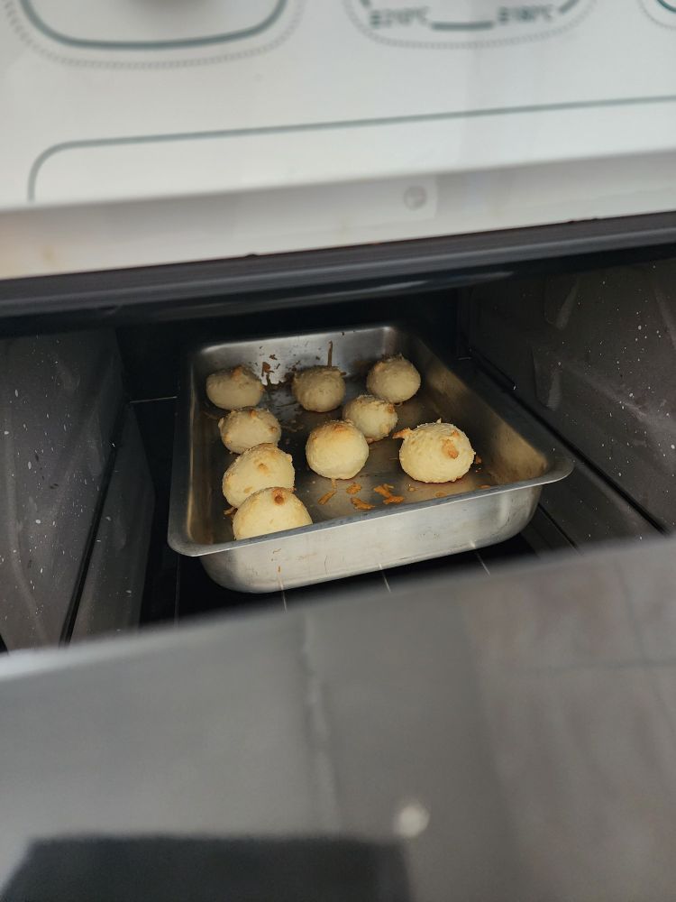 Forma de pães de queijo assados dentro do fogão